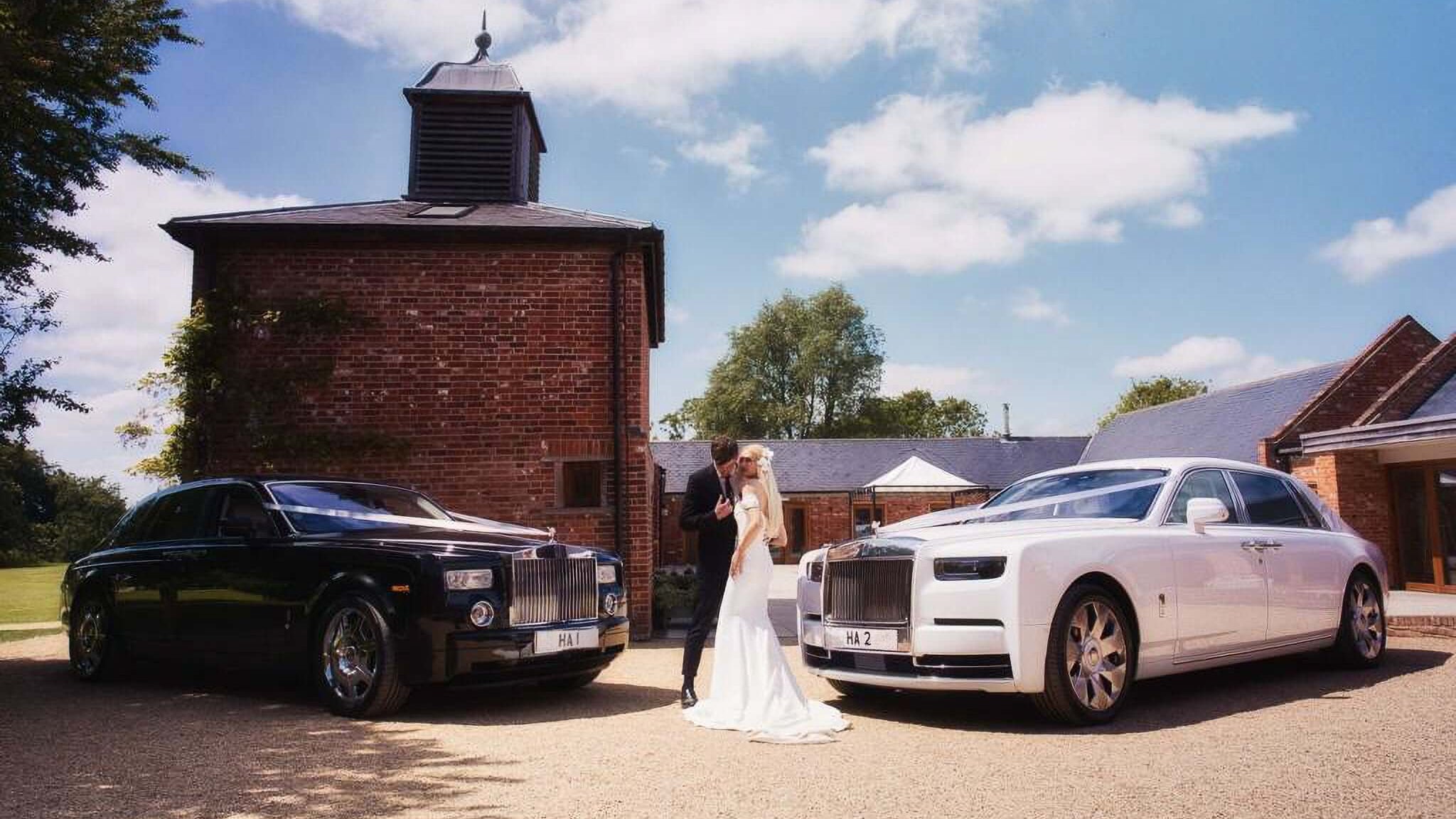 J Chauffeurs luxury wedding cars: black and white Rolls Royce Phantom with couple, perfect for UK wedding hire