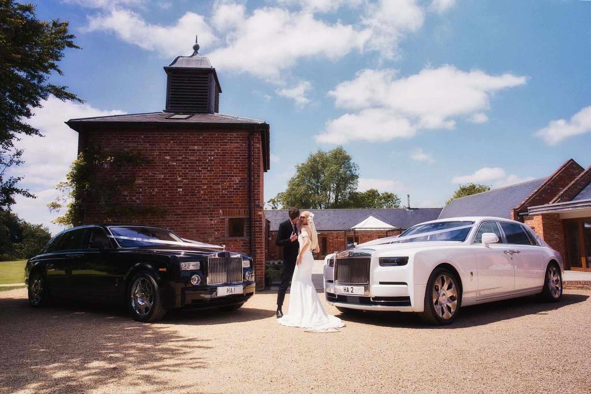 J Chauffeurs luxury wedding cars: black and white Rolls Royce Phantom with couple, perfect for UK wedding hire